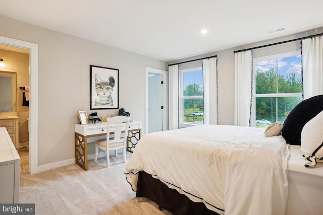 bedroom featuring light carpet and multiple windows