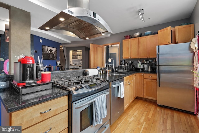 kitchen with light hardwood / wood-style flooring, appliances with stainless steel finishes, island range hood, kitchen peninsula, and dark stone counters