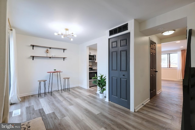 interior space with baseboards, visible vents, and light wood-type flooring