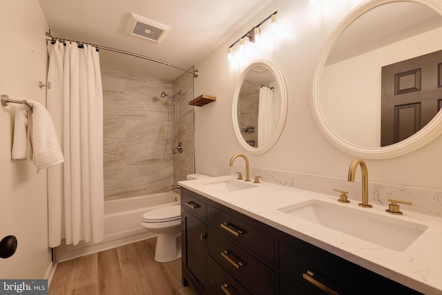 full bathroom featuring wood-type flooring, toilet, vanity, and shower / bath combo with shower curtain