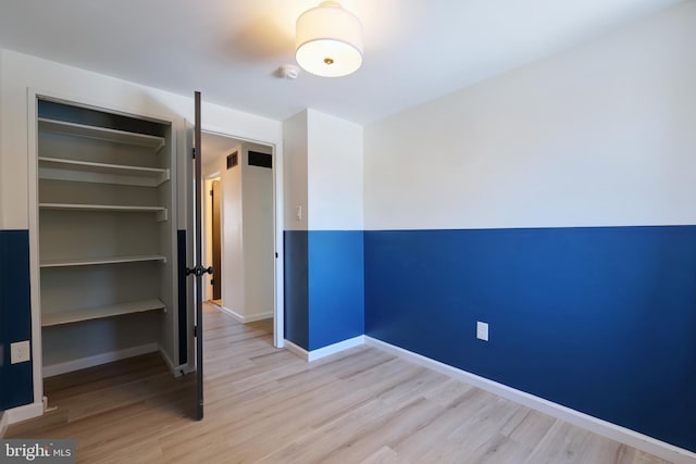 unfurnished bedroom featuring a closet and light wood-type flooring