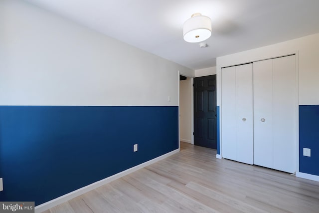 unfurnished bedroom with a closet and light wood-type flooring