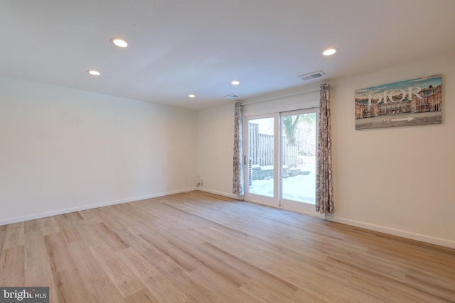 empty room featuring light wood-type flooring, visible vents, baseboards, and recessed lighting