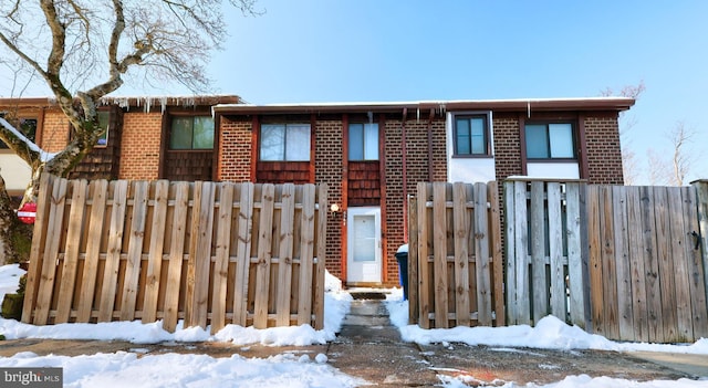 view of front of property featuring fence and brick siding