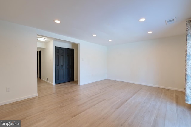 spare room featuring light wood-style flooring, recessed lighting, and baseboards