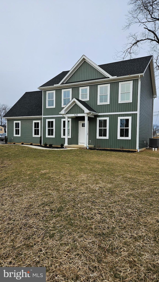 view of front of property featuring cooling unit and a front lawn