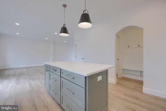 kitchen with a center island, gray cabinetry, light hardwood / wood-style floors, and decorative light fixtures