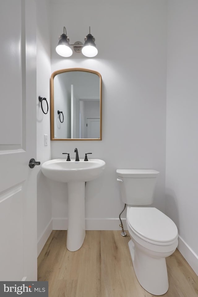 bathroom featuring wood-type flooring and toilet