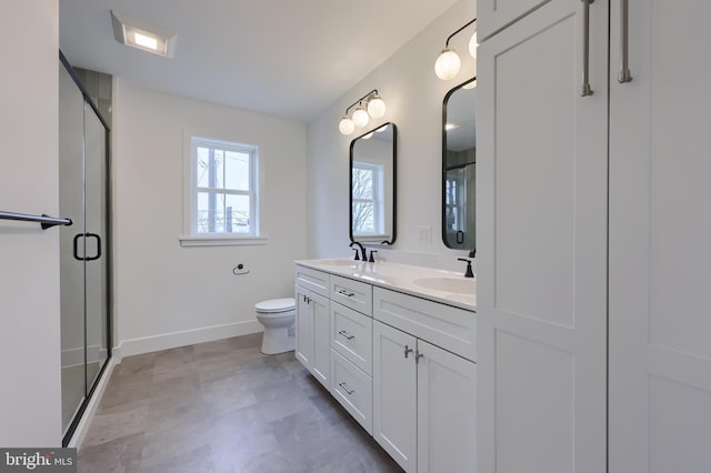 bathroom with vanity, a shower with shower door, and toilet