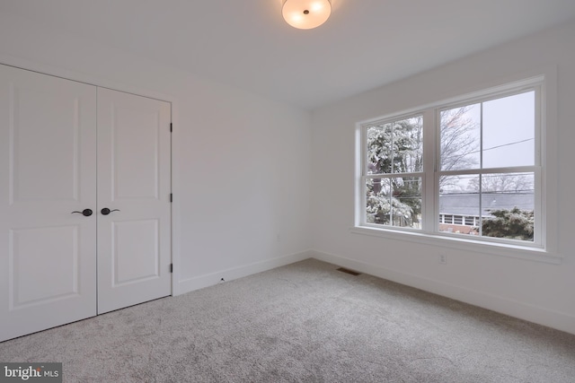 unfurnished bedroom featuring carpet floors and a closet