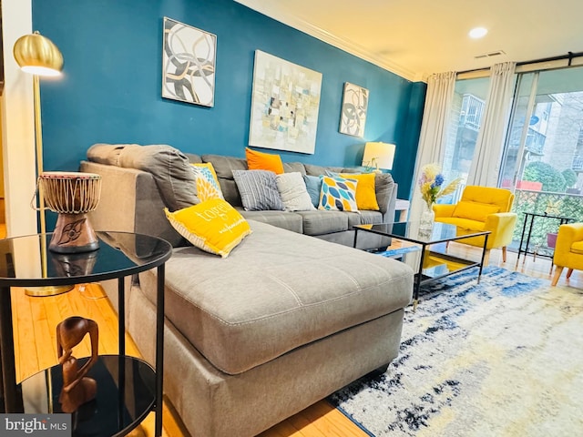 living room with crown molding, wood-type flooring, and expansive windows