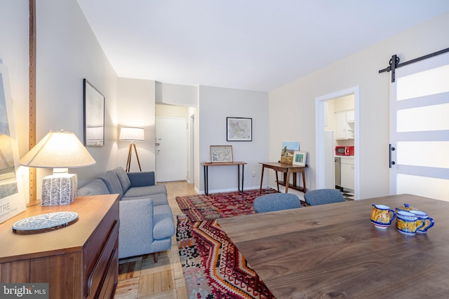 dining area featuring a barn door and light parquet floors