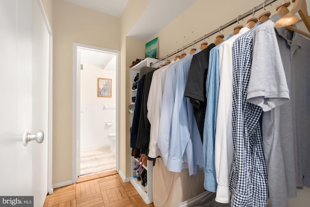 walk in closet with parquet floors