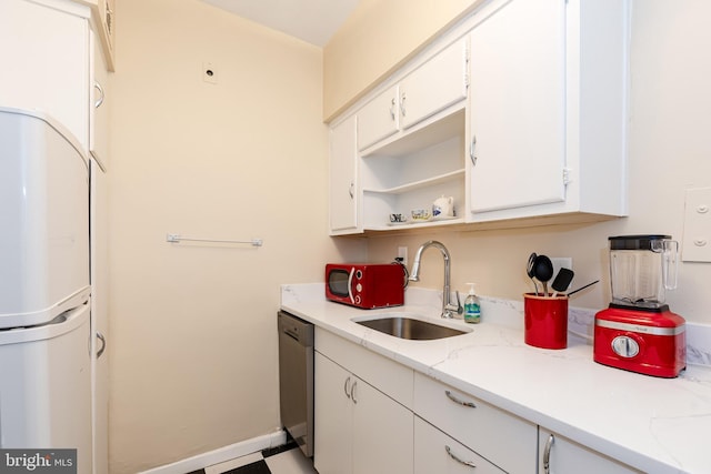 kitchen with sink, white cabinetry, refrigerator, stainless steel dishwasher, and light stone countertops