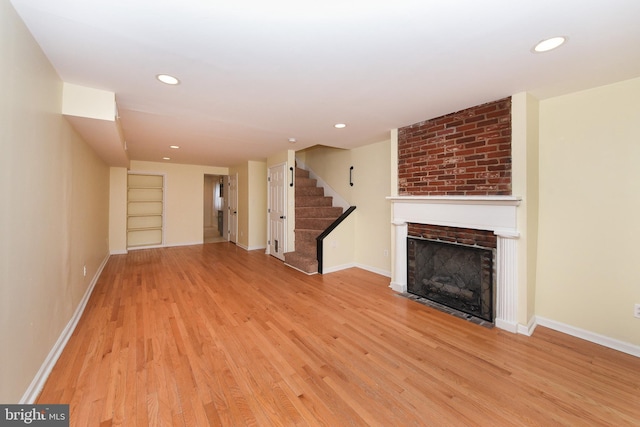 unfurnished living room with light wood-type flooring and a fireplace