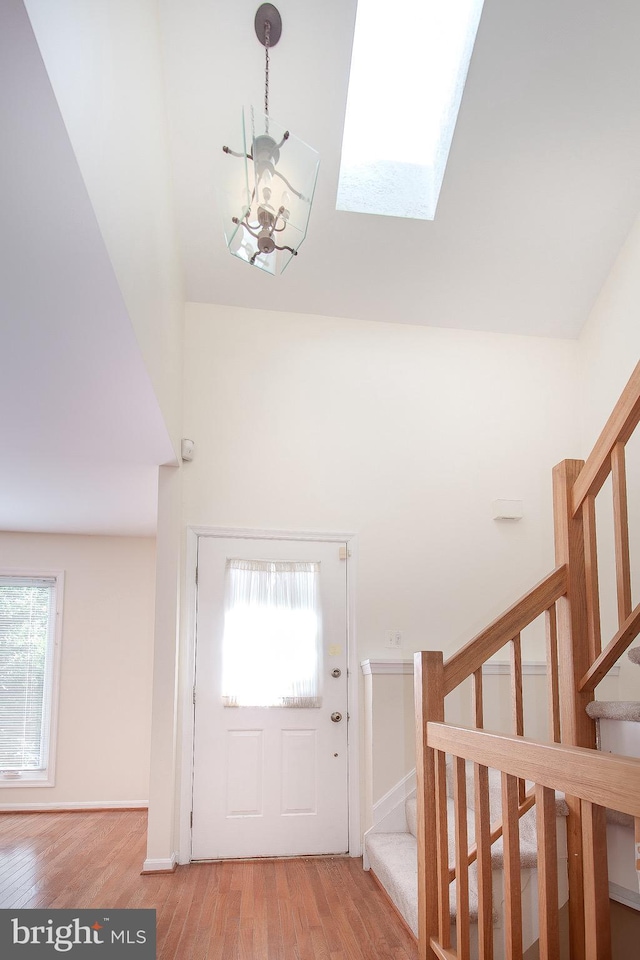 foyer featuring plenty of natural light, light hardwood / wood-style floors, and a skylight