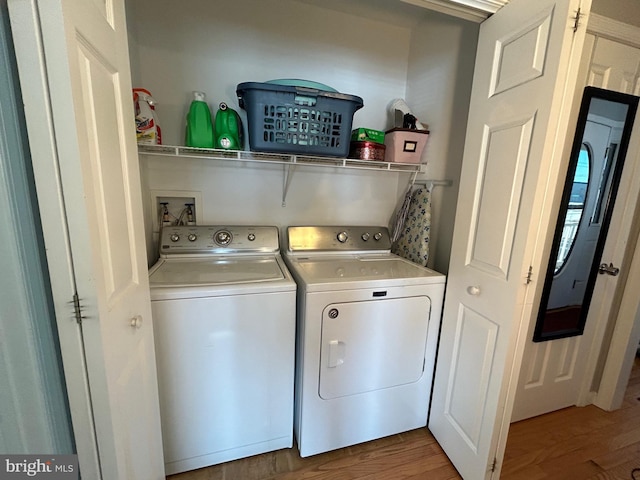 washroom with wood-type flooring and independent washer and dryer