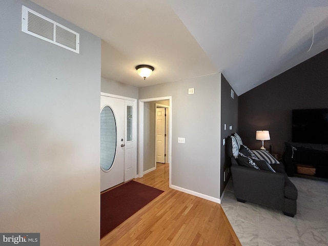 foyer with vaulted ceiling and light hardwood / wood-style flooring