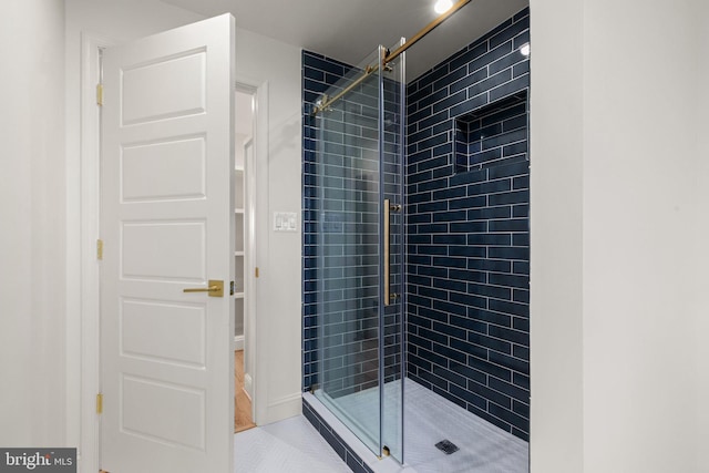 bathroom with tile patterned floors and a shower with door