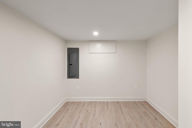 empty room with electric panel and light wood-type flooring