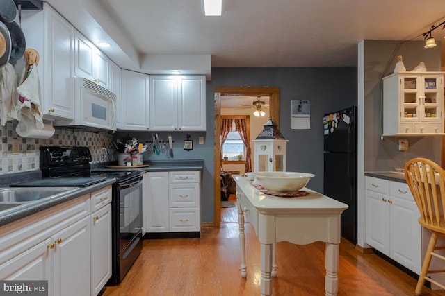 kitchen featuring black appliances, backsplash, white cabinets, and light wood finished floors