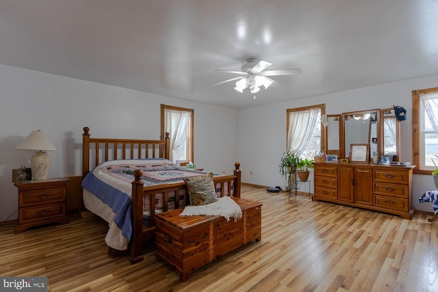 bedroom featuring light wood-type flooring, a ceiling fan, and baseboards