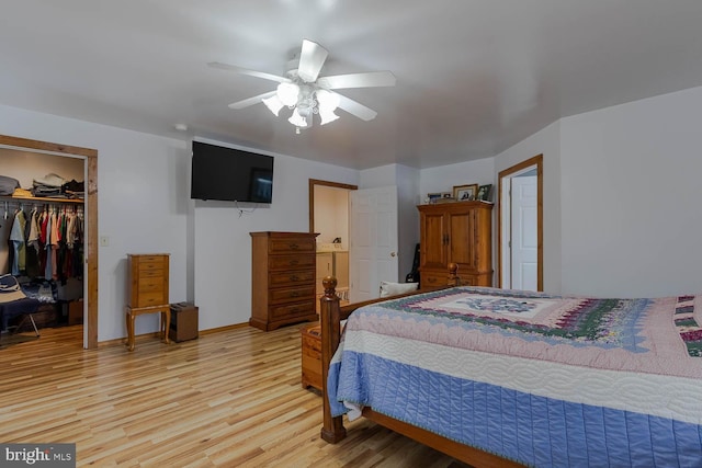 bedroom with ceiling fan, baseboards, light wood-style floors, a spacious closet, and a closet