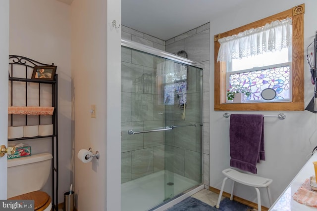 bathroom featuring a stall shower and toilet