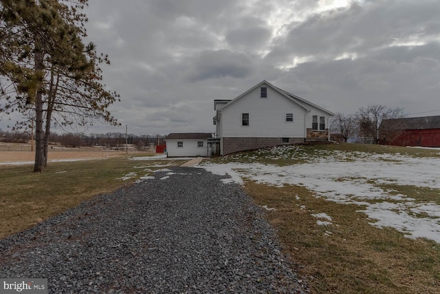 view of side of property featuring gravel driveway