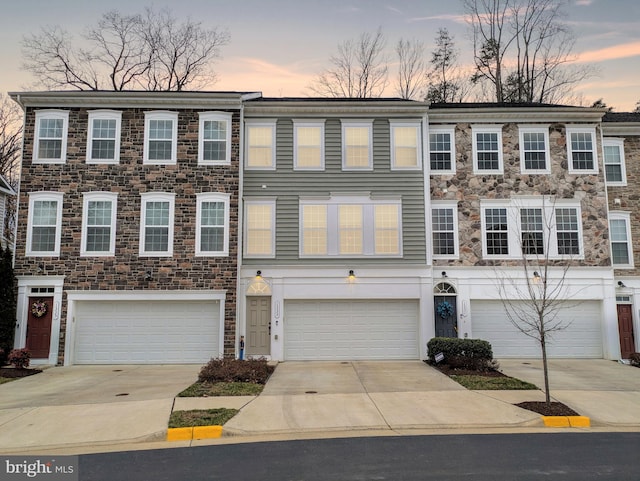 multi unit property featuring concrete driveway and an attached garage