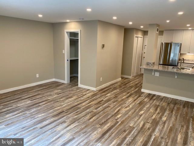 unfurnished living room with dark hardwood / wood-style flooring and sink