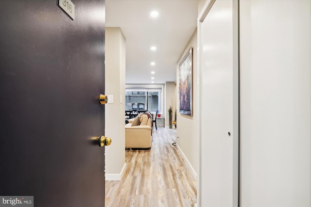 hallway with light hardwood / wood-style floors