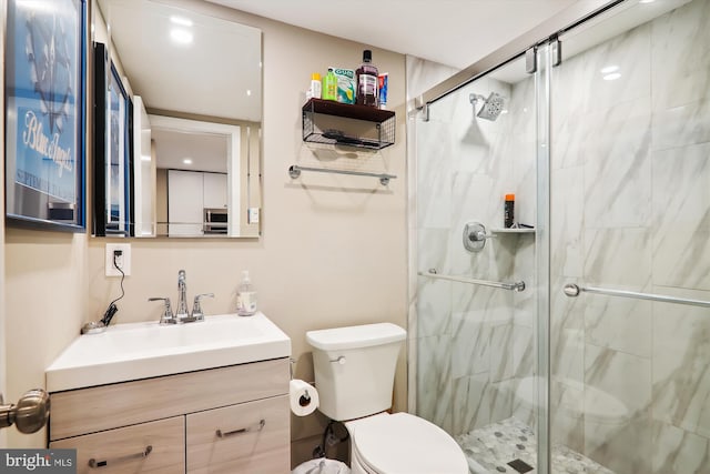 bathroom with an enclosed shower, vanity, and toilet