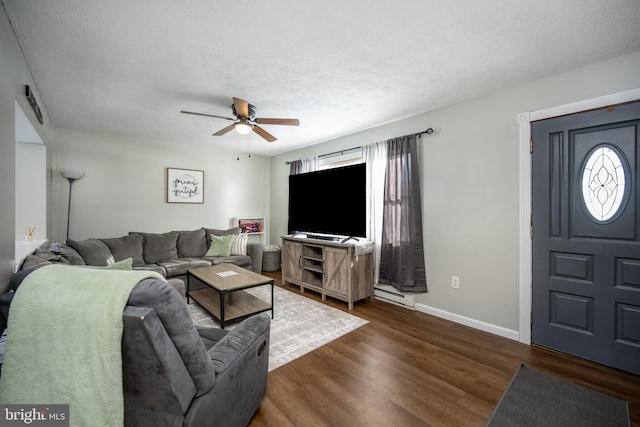 living room with dark hardwood / wood-style flooring, ceiling fan, and a textured ceiling