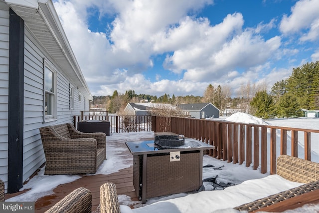 snow covered deck featuring an outdoor fire pit