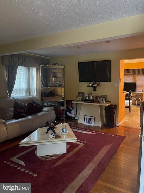 living room featuring hardwood / wood-style flooring and a textured ceiling