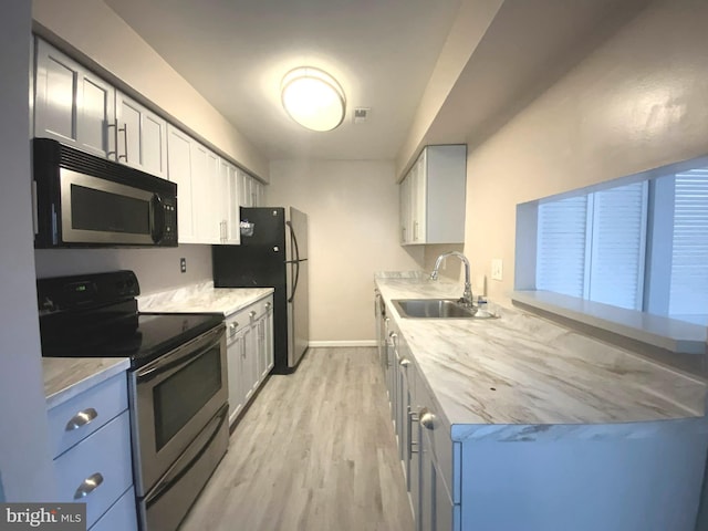 kitchen with stainless steel appliances, sink, and light wood-type flooring