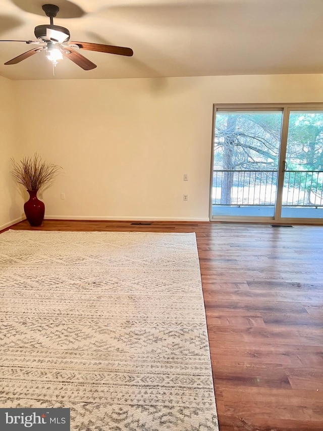 empty room with a ceiling fan and wood finished floors