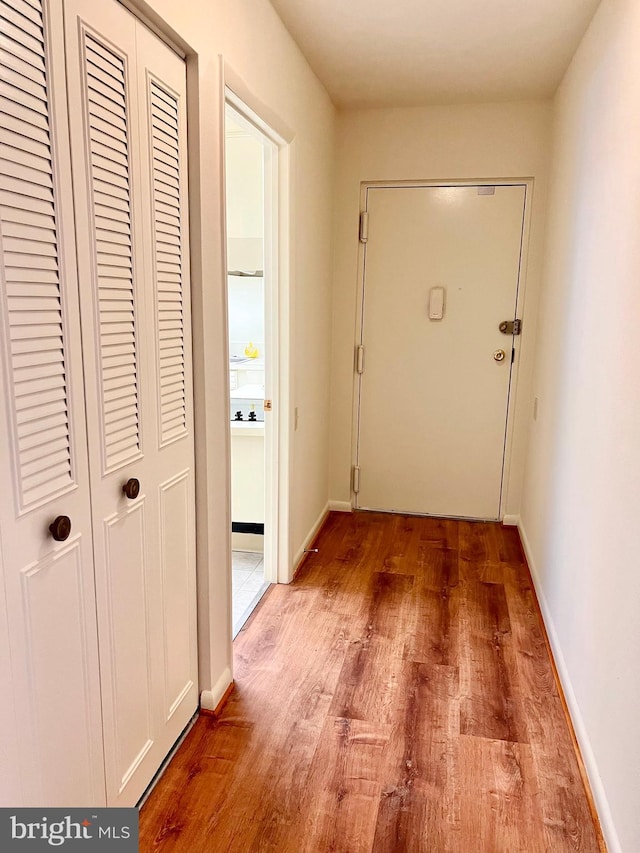 hall featuring baseboards and wood finished floors