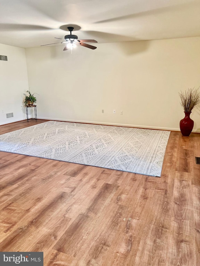 spare room featuring visible vents, ceiling fan, and wood finished floors