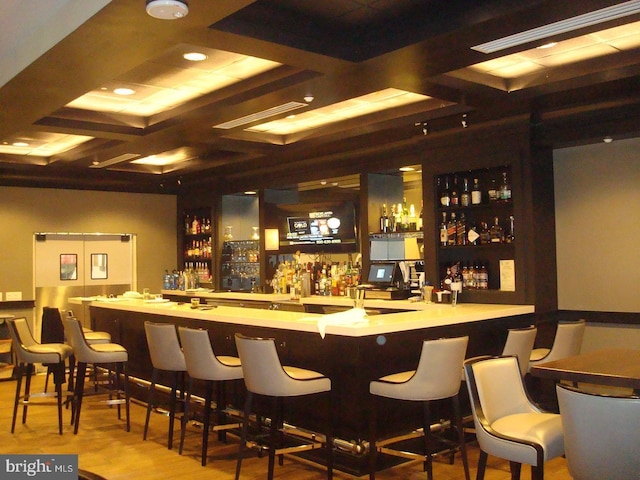 bar featuring beamed ceiling, coffered ceiling, and wood finished floors