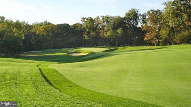 view of community with view of golf course and a lawn