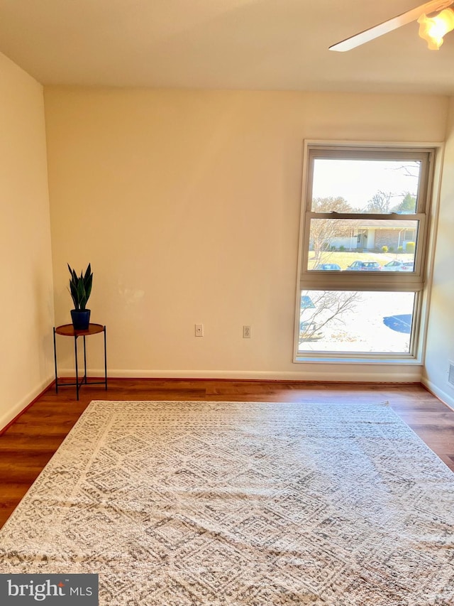 empty room featuring dark wood finished floors and baseboards