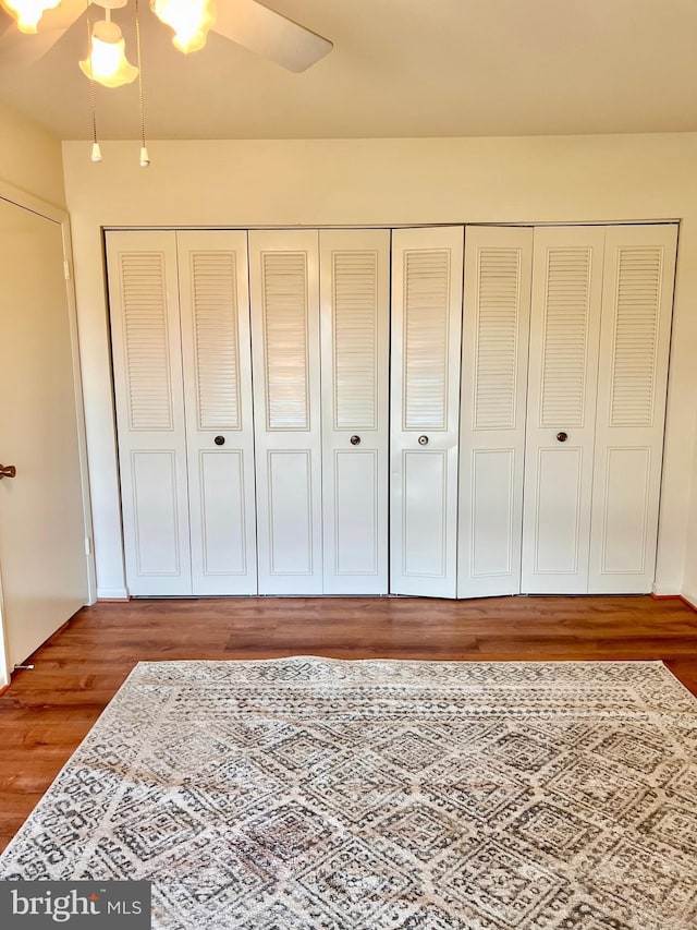 bedroom with a closet, a ceiling fan, and wood finished floors