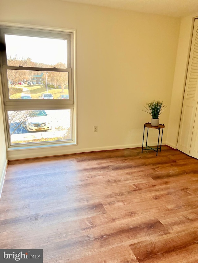 unfurnished room with light wood-style flooring and baseboards