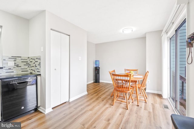 dining room with light wood finished floors, baseboards, and visible vents