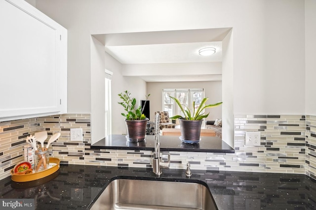 kitchen featuring tasteful backsplash, white cabinetry, and a sink