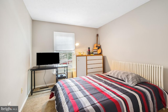 bedroom with baseboards and light colored carpet