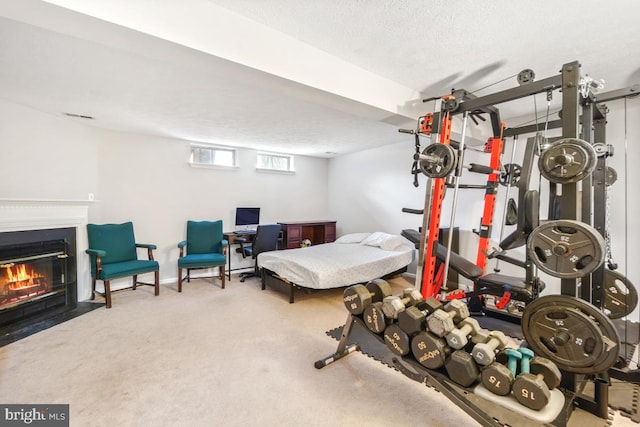 bedroom with a fireplace with flush hearth, carpet, visible vents, and a textured ceiling