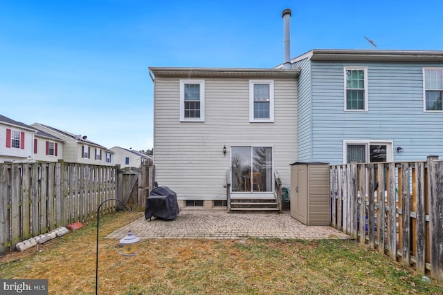 back of property with entry steps, a patio area, a fenced backyard, and a yard